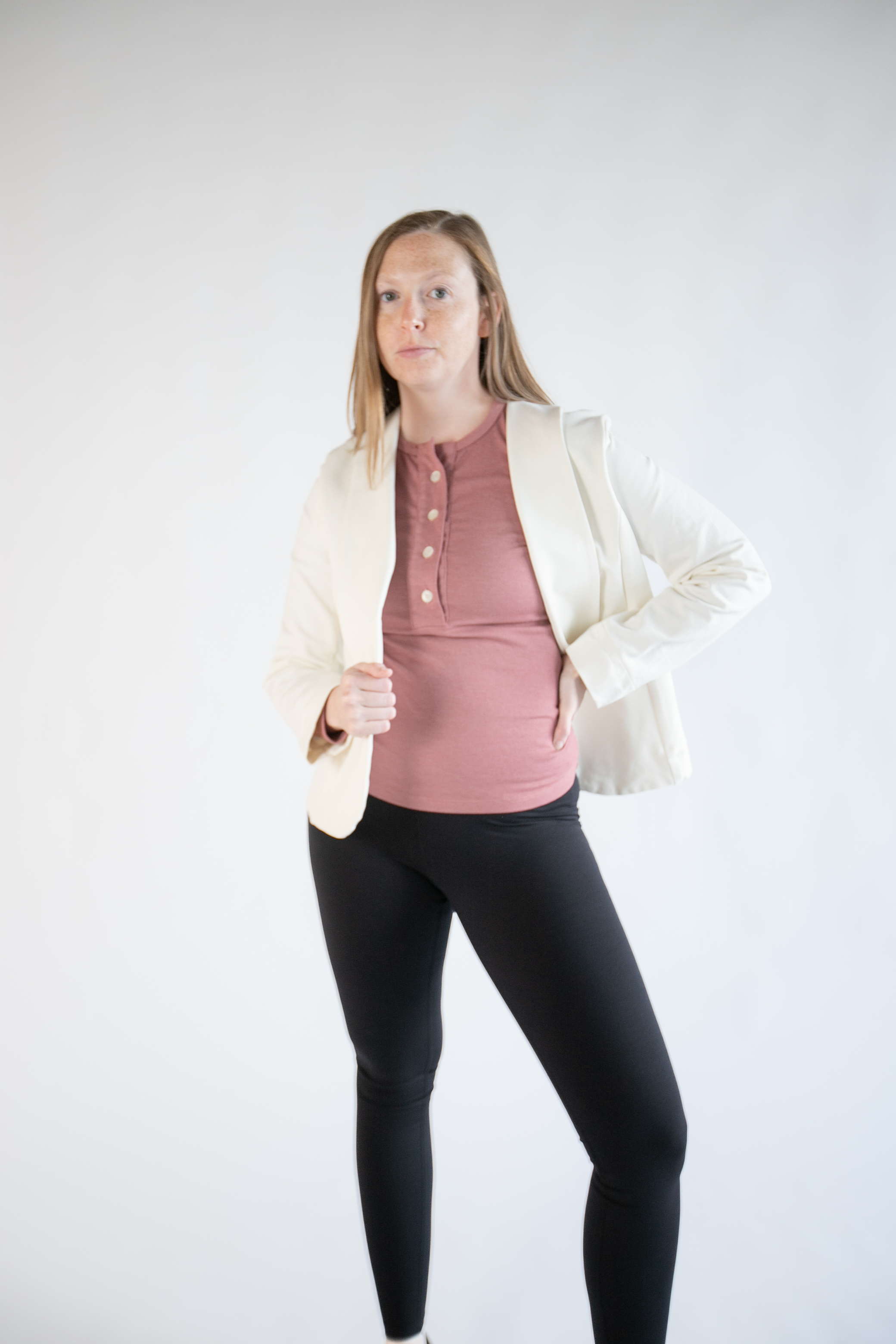 Leslye Young in a cream blazer and rose henley top against a white studio backdrop.